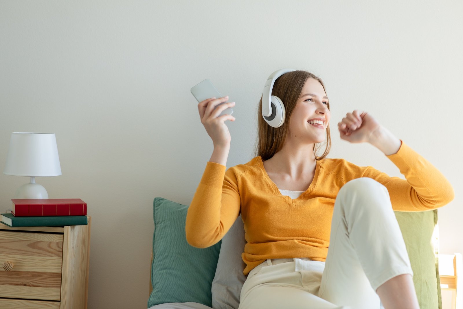 Girl Sitting on Bed Listening to Music With Headphones